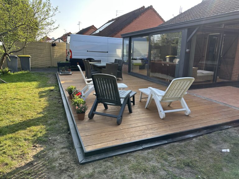 Terrasse bois KitTerrasse Pro aménagée avec transats, salon de jardin et pots de fleurs.