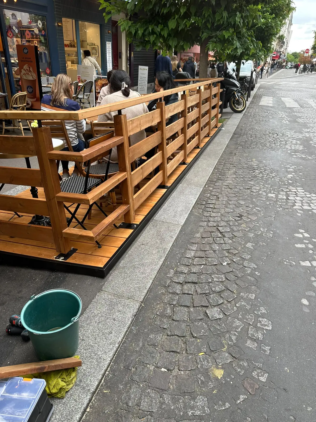 Après : contre-terrasse en bois Marc Verde pleine de clients sur la même place de stationnement