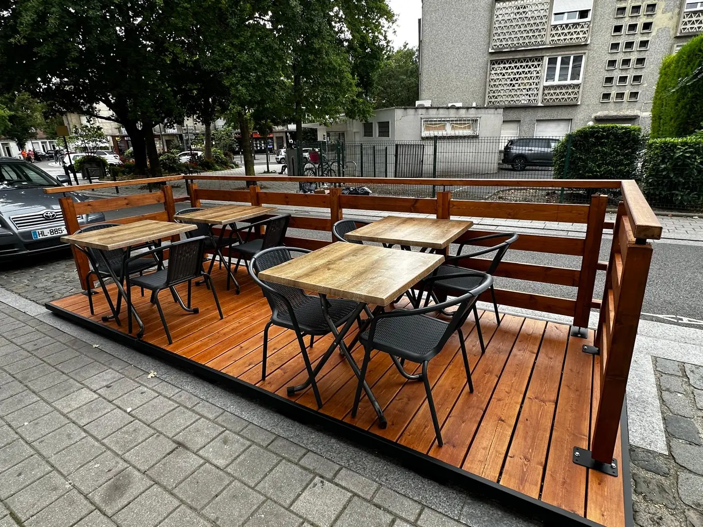 Contre-terrasse modulaire Marc Verde en bois installée sur deux places de stationnement devant une brasserie à Valenciennes