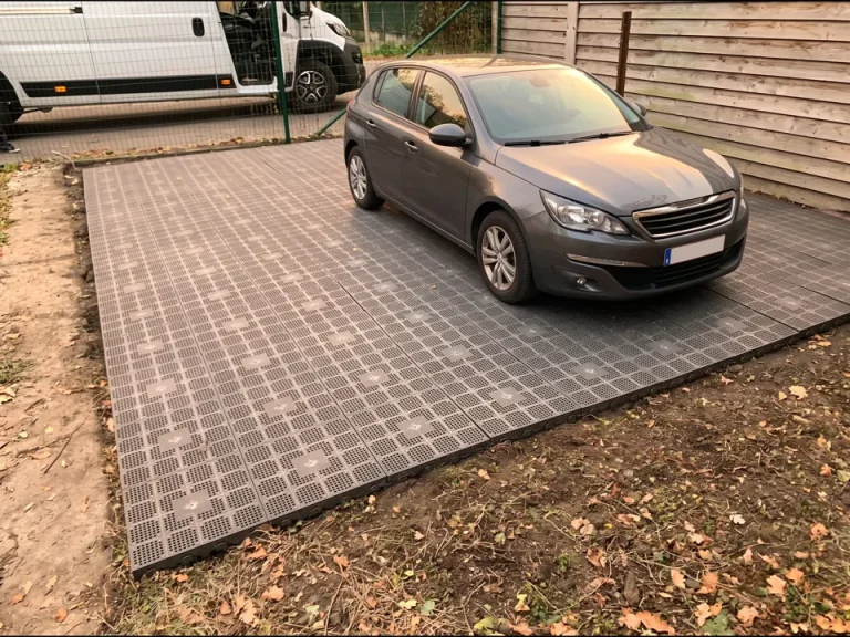 Place de parking réalisée en dalles clipsables Dalle Connect grises sur terrain, voiture garée